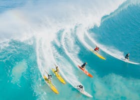 A dynamic shot of surfers riding a big wave at Waimea Bay, Hawaii. Ideal for sports and adventure themes.